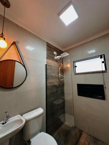 een badkamer met een toilet, een wastafel en een douche bij cantinho da padroeira in Aparecida