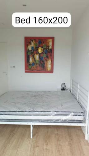 - un lit dans une chambre avec une photo sur le mur dans l'établissement Le Courant - 1 Chambre avec une vue imprenable, à Mimizan-Plage