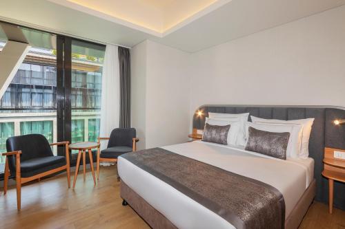 伊斯坦布尔Meroddi Beyoğlu Residence的一间带床和大窗户的酒店房间