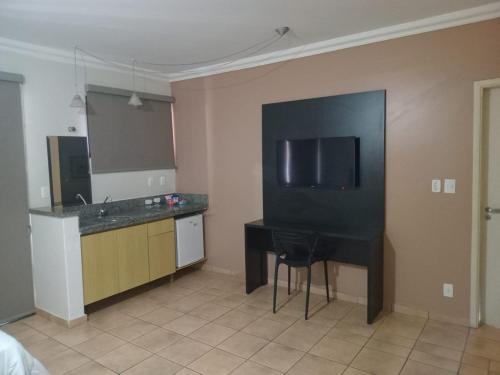 a kitchen with a black table and a black desk at Plaza Inn Flat Araxá in Araxá