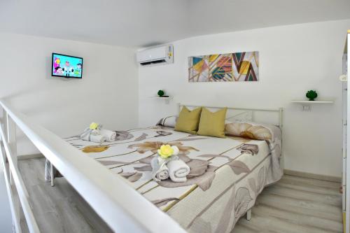 a white bedroom with a bed with towels and pillows at Bed and breakfast Notti in Salento in Melissano