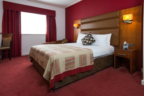a hotel room with a large bed and a window at Mercure Newbury West Grange Hotel in Thatcham