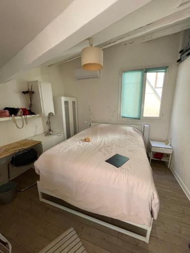 une chambre avec un lit avec un ordinateur portable dessus dans l'établissement Duplex calme avec clim, idéal pour flâner à Aix, à Aix-en-Provence