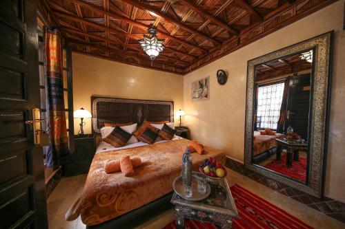 1 dormitorio con 1 cama grande y espejo grande en Riad Africa, en Marrakech