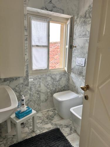 a bathroom with a sink and a toilet and a window at Bon Bon Luxury di piazza San Secondo in Asti