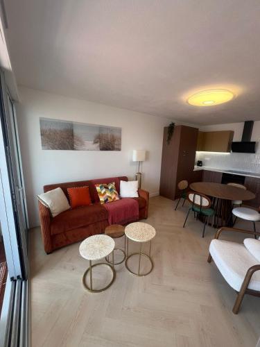 un salon avec un canapé et une table dans l'établissement Beautiful apartment with sea view, au Grau-du-Roi