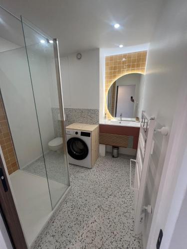 une salle de bain avec douche et lavabo et une machine à laver dans l'établissement Beautiful apartment with sea view, au Grau-du-Roi