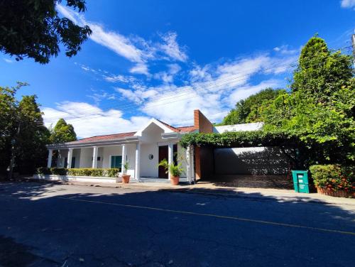 a white house with a garage on a street at Casa Condominio El Peñón Girardot in Girardot