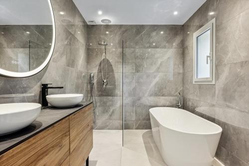 une salle de bain avec deux lavabos et une douche en verre dans l'établissement House with pool, à Vallauris