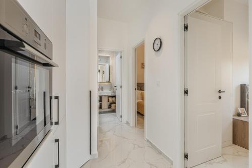 a white kitchen with a clock on the wall at Njivice Coastal Oasis in Njivice