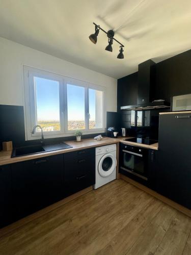 une cuisine avec une machine à laver et un évier dans l'établissement L'atelier Panoramique, à Blois