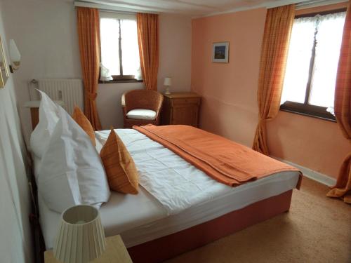 a bedroom with a bed with an orange blanket on it at Historisches Fachwerkhaus in Reifferscheid