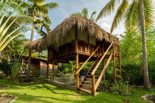 a resort with a straw hut with a staircase at Casa Chapolin Boutique Guesthouse in Palomino
