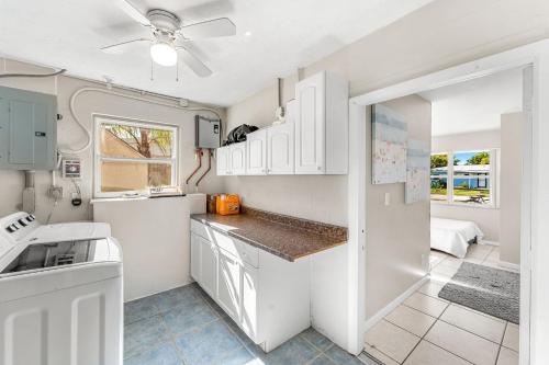 a kitchen with white cabinets and a ceiling fan at 721 Java Rd in Cocoa Beach