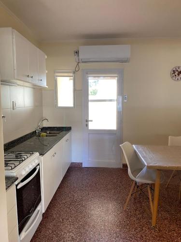 a kitchen with a stove and a sink and a table at N&G Alquiler Temporal in Venado Tuerto