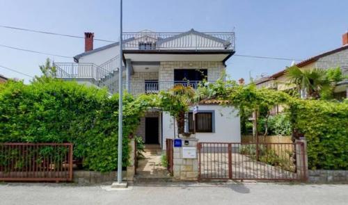 a house with a fence in front of it at Villa Hanka Umag - 3 verschiedene Whg - 40 qm 3 Pers, 50 qm bis 4 Pers oder 70 qm bis 5 Pers, Balkone, nur 70 m zum Strand, von 3 bis max 5 Personen, WLAN, SAT-TV, Klima, Küche, Parkplätze,ruhig gelegen in Umag
