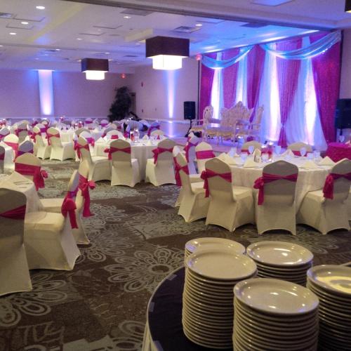 a banquet hall with white tables and white chairs at Holiday Inn Orlando East-UCF Area by IHG in Orlando