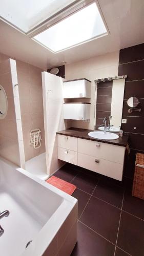 une salle de bain avec un lavabo et une baignoire dans l'établissement Grande maison 4 chambres 5 lits Les Sables d'Olonne, à Les Sables-dʼOlonne