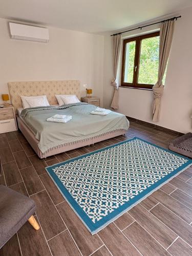 a bedroom with a bed and a blue rug on the floor at Sárffy Vendégház in Szőce