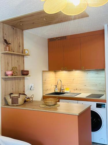 une cuisine avec un évier et une machine à laver dans l'établissement Appartement 5 pers Serre Chevalier Cabane Bohème, à Saint-Chaffrey