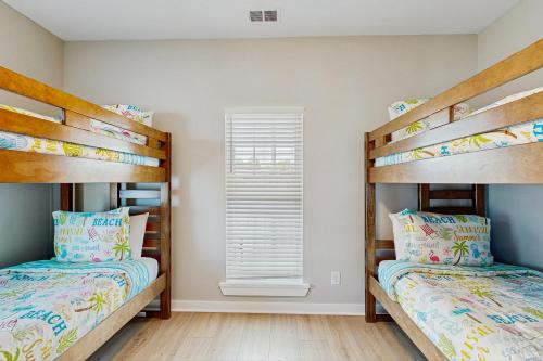 two bunk beds in a room with a window at A Shore Thing in Edisto Beach