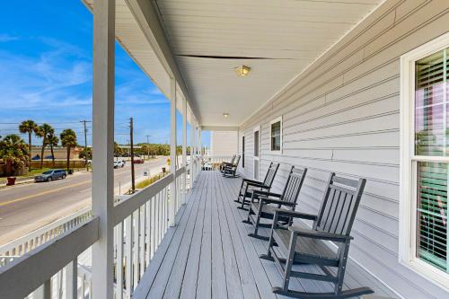 a row of chairs sitting on the porch of a house at A Shore Thing in Edisto Beach