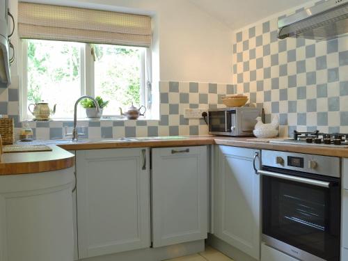 a kitchen with white cabinets and a microwave at The Coach House in Southampton