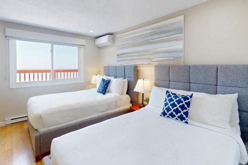 una camera da letto con due letti e una finestra di The Driftwood Deck 5A a Wasaga Beach