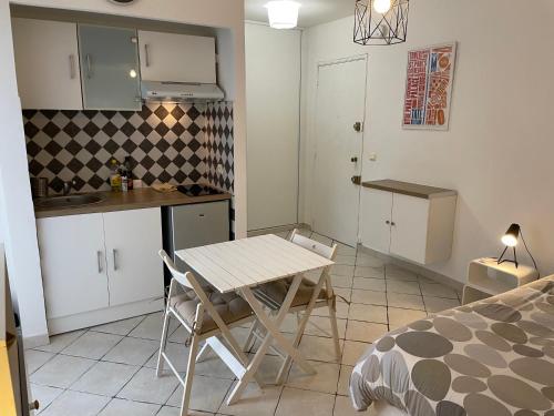 a small kitchen with a table and chairs in a room at T1 Centre ville Carré d'or proche plage in Ajaccio