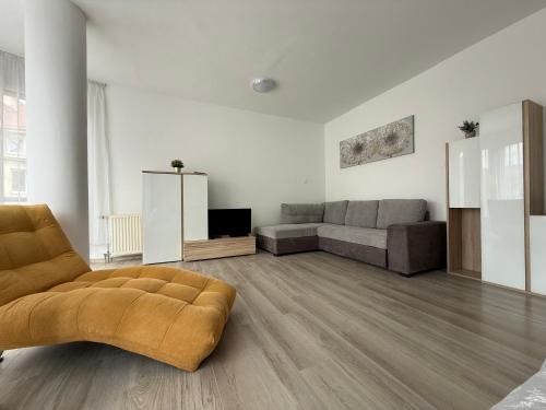 ein Wohnzimmer mit einer Couch und einem Sessel in der Unterkunft F25 Apartman in Pécs