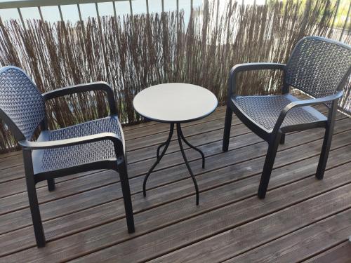 2 chaises et une table sur une terrasse dans l'établissement À 100 mètres du Métro !, à Vaulx-en-Velin