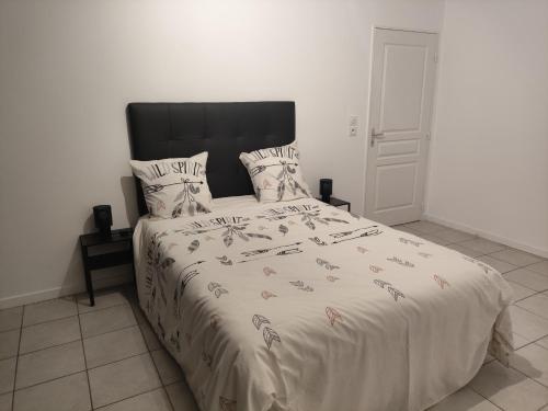 une chambre avec un grand lit avec une tête de lit noire dans l'établissement À 100 mètres du Métro !, à Vaulx-en-Velin