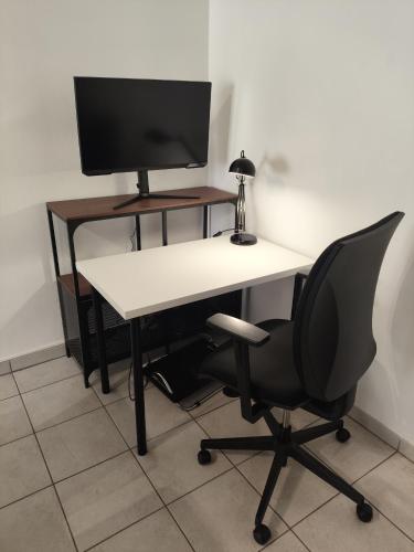 un bureau avec un écran d'ordinateur et une chaise dans l'établissement À 100 mètres du Métro !, à Vaulx-en-Velin