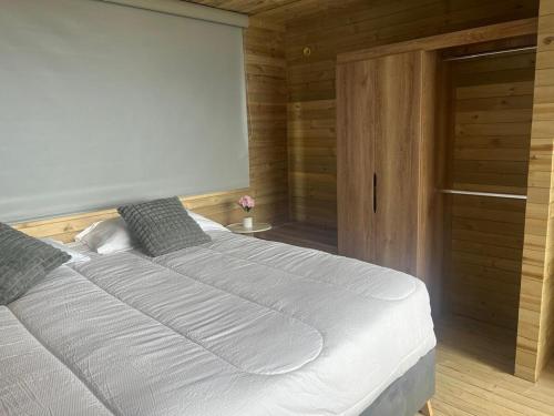 a bedroom with a large white bed in a room at Cabaña de lujo alpina in Villa de Leyva