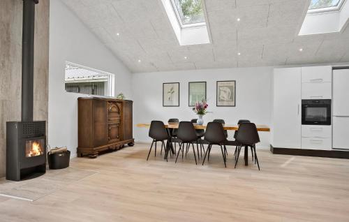 a dining room with a table and chairs and a fireplace at 3 Bedroom Stunning Home In Spøttrup in Spottrup