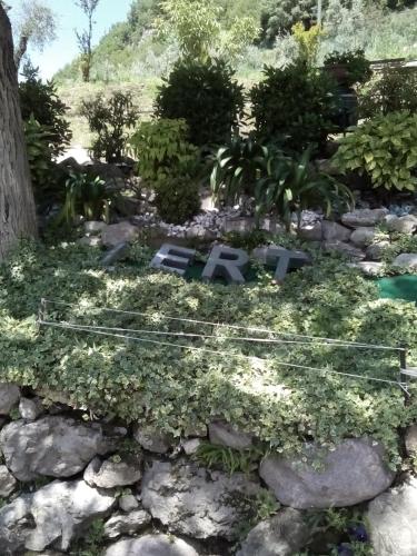 a garden with a sign in a pile of rocks at Agriturismo Cascina Lert in Marone