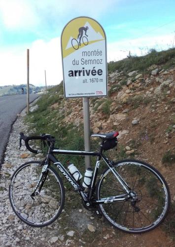 un vélo garé à côté d'un panneau sur le côté d'une route dans l'établissement House near Annecy & Semnoz, à Quintal
