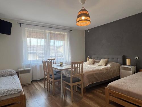 a bedroom with a bed and a table and chairs at Pokoje Gościnne REST in Karwia
