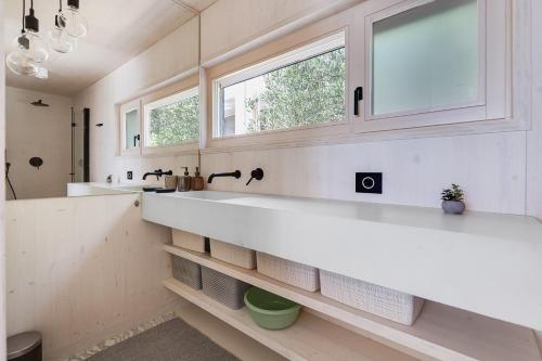 a bathroom with two sinks and a window at Villa Nautilus Buqez Resort in Drage