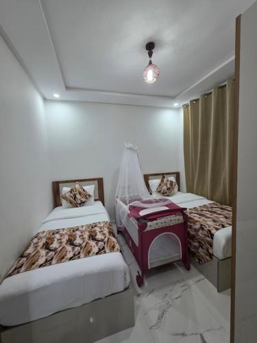 a room with two beds and a piano in it at Appart moderne nador al jadid près de la corniche in Nador