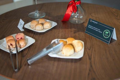 a table with plates of food on a table at Hotel Heritage in Sao Paulo