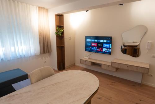 a living room with a tv on a wall at Modern Bazaar Apartment in Gjakove