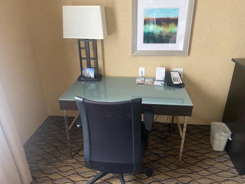 a desk in a hotel room with a lamp and a phone at Wingate by Wyndham Fort Saskatchewan in Fort Saskatchewan