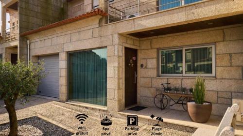 a house with a garage door and a table in front of it at Casa Dominique - Spa & Confort in Louro