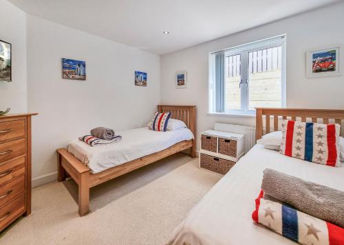 una camera da letto con due letti e una finestra di Point View - Award Winning Apartments with Private Hot Tub & Parking a Croyde