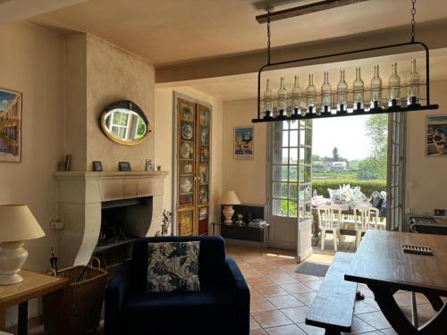 un salon avec une cheminée et une table dans l'établissement Béhuard : Maison vue Loire, à Behuard