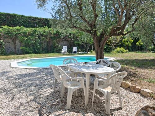 - une table et des chaises blanches à côté de la piscine dans l'établissement Villa 8 personnes, piscine, au calme, à Grasse