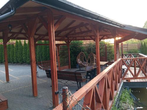 a wooden pavilion with a table and bench on a patio at Pokoje Apartamenty w Dolinie Rospudy in Skazdub Stary
