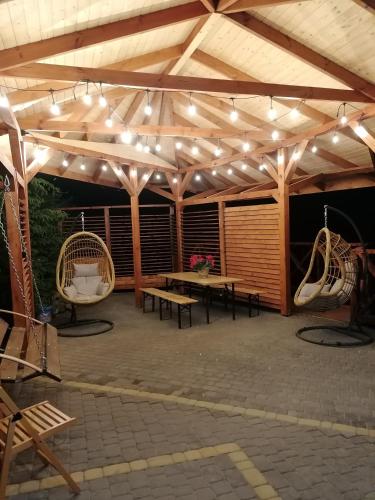 a pavilion with a picnic table and chairs and lights at Pokoje Apartamenty w Dolinie Rospudy in Skazdub Stary