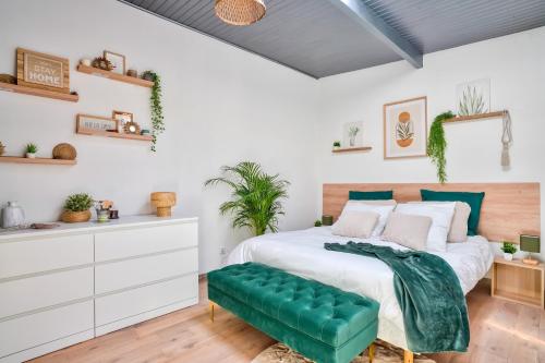 - une chambre avec un grand lit et un banc vert dans l'établissement Charmante maison indépendante avec terrasse verdoyante au calme absolu aux portes de Paris, à Houilles